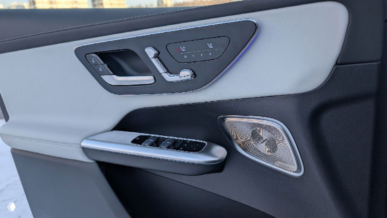 Деталь дверной панели Mercedes GLC 300: элементы управления сиденьями и подсветка, белая обивка и декоративные вставки в салоне автомобиля