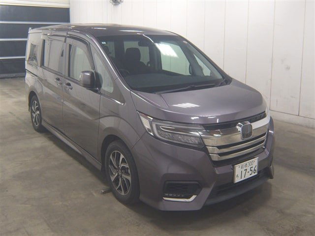 Экстерьер серого Honda Step Wagon Sensing RP3: передняя трёхчетвертная проекция с японским номером, автомобиль в ангаре аукциона.