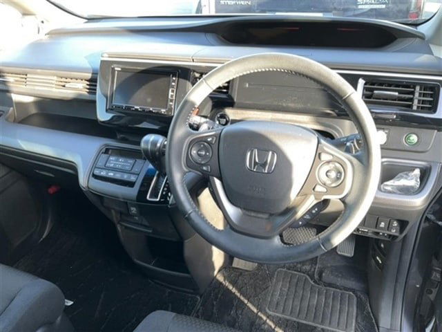 Салон Honda Step Wagon: вид рулевого колеса, панель приборов и центральная консоль, фотография состояния интерьера автомобиля.