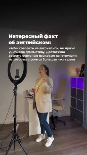 Фото Марии Малышевой в учебной студии с кольцевой лампой и фоном: автор анонсирует курс по базовым грамматическим структурам