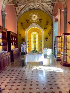 Яркий интерьер бутика Aquazzura: прямой ракурс на арочную подсвеченную нішу, витрины и центральный экспозиционный стол с обувью на подставках.