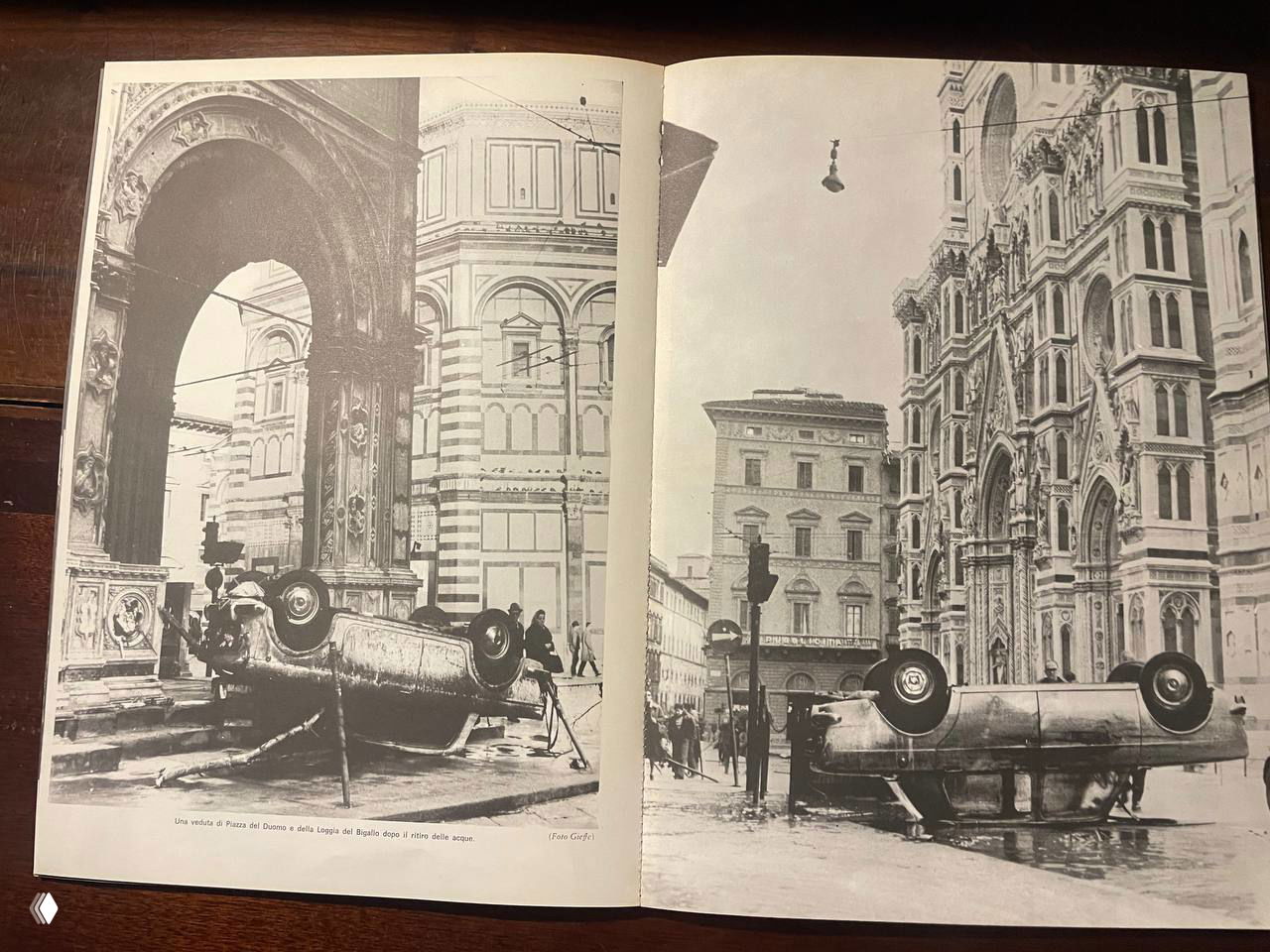 Разворот книги: две страницы с крупными чёрно-белыми кадрами — опрокинутые машины и архитектура центра Флоренции