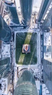 Аэрофотосъёмка между высотками: человек на плите посреди двора — геометрический AI‑кадр с акцентом на масштаб и композицию.