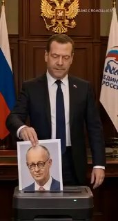 Дмитрий Медведев в официальной обстановке опускает распечатанный портрет в шредер на фоне герба РФ и флага — кадр из ИИ‑видео.