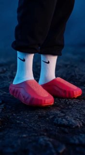 Ноги в белых носках и розовых тапочках на темном фонe — минималистичный визуал, демонстрирующий экспериментальный AI‑стиль и контрастные цвета.