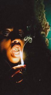 Человек зажигает огонь, дым и фактура лица в тёмной сцене — драматичный AI‑портрет с киношной подсветкой и сильным контрастом.