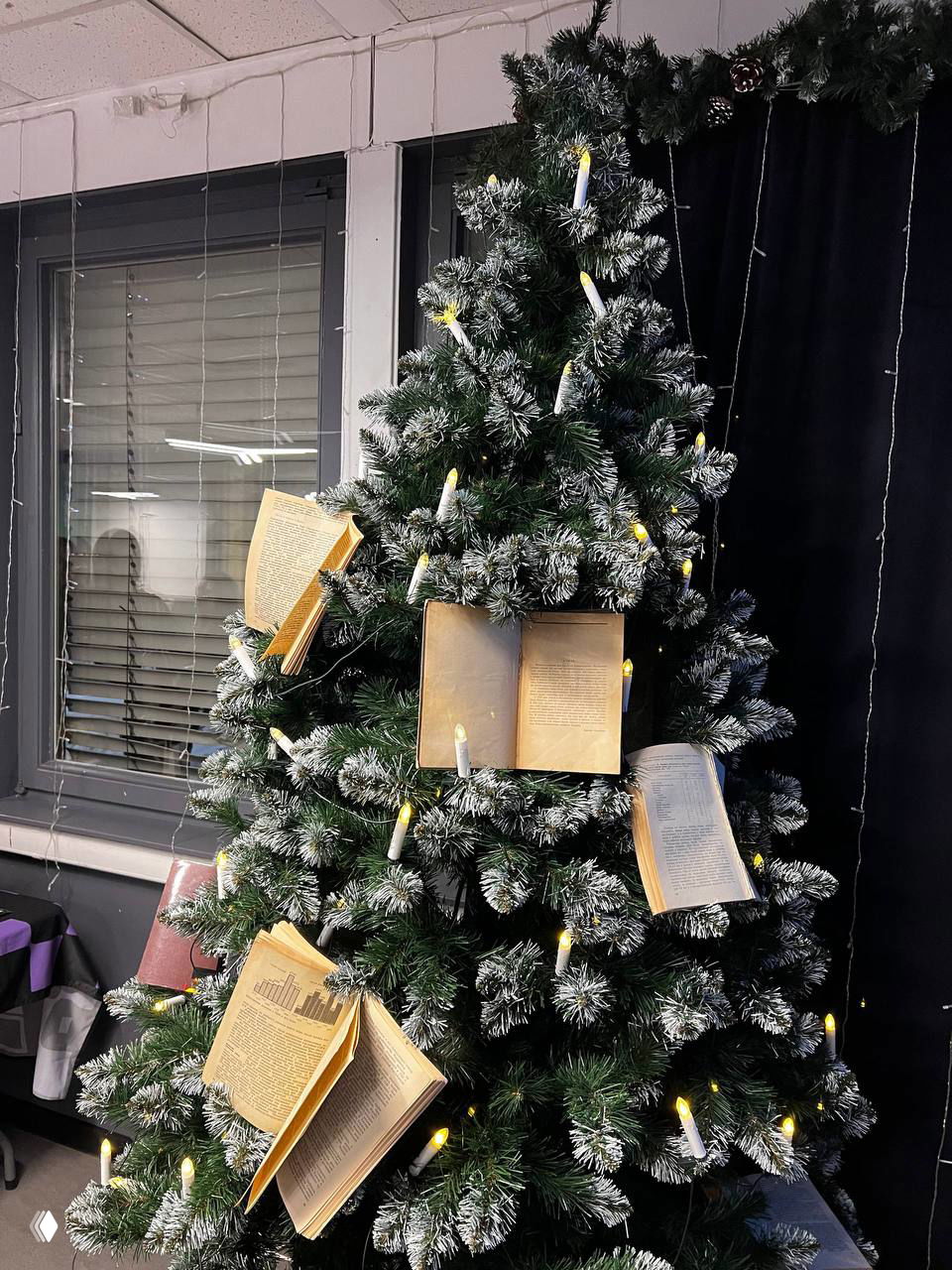 Новогодняя ёлка, украшенная открытими страницами книг и гирляндами, создаёт творческую атмосферу в пространстве IThub.