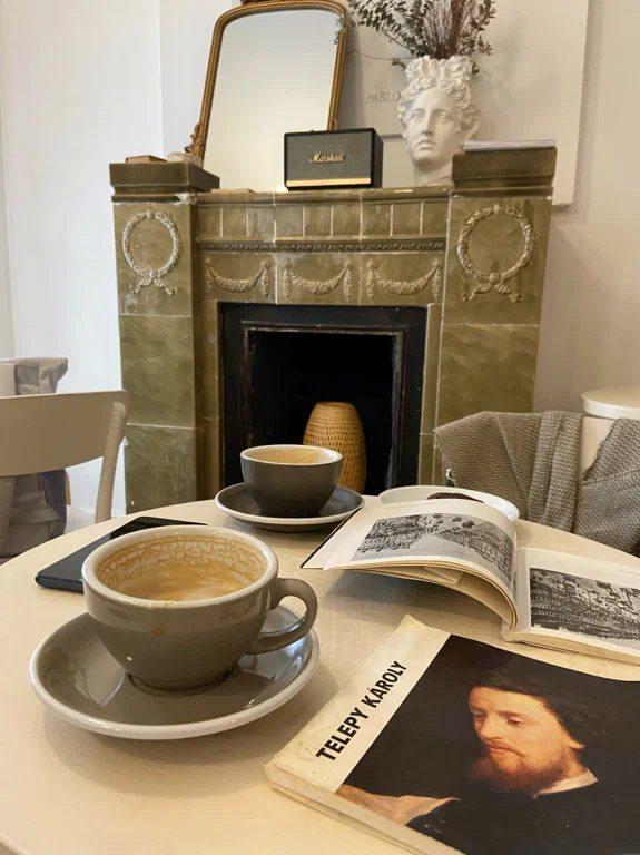 Кофе на столе рядом с открытой книгой и чашкой: спокойная рабочая сцена с литературной атмосферой и утренним кофе для продуктивного дня.