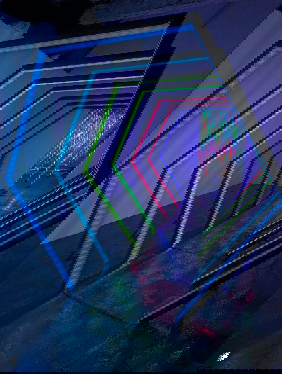 Неоновый туннель из геометрических рам с многоцветной подсветкой ведёт в следующую инсталляционную комнату арт‑пространства.