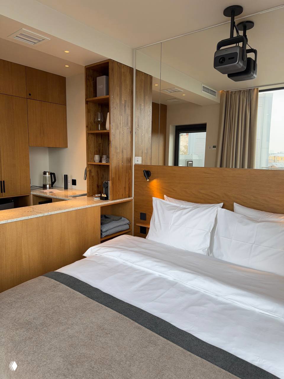 Парная внутри домика: деревянные скамьи и печь с белыми камнями, тёплая древесная отделка — маленькая уютная сауна в глэмпинге.