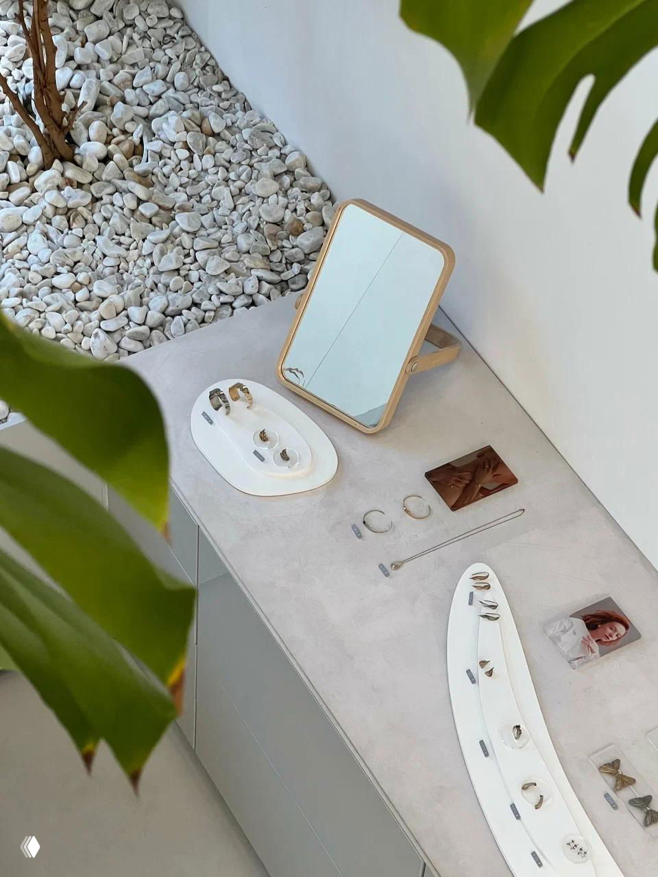 Витрина и столик с украшениями Fjord: зеркальце, подставки и аккуратно разложенные кольца и серьги на светлом фоне магазина-кофейни.