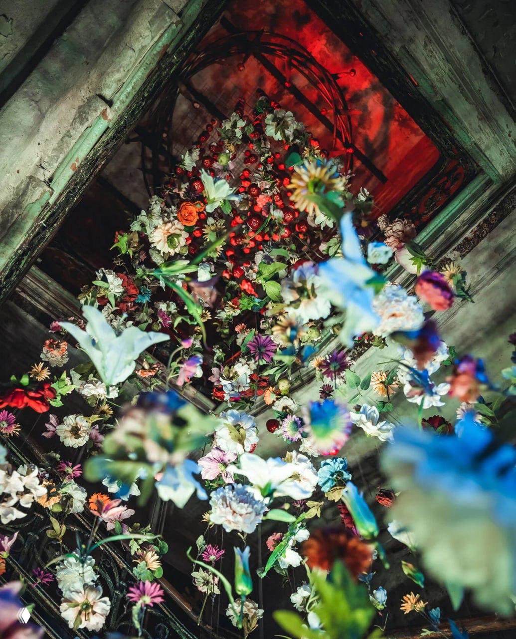 Подвешенные цветы и лианы создают эффект цветущего сада под старинным сводом церкви в экспозиции «История всего» в Анненкирхе.