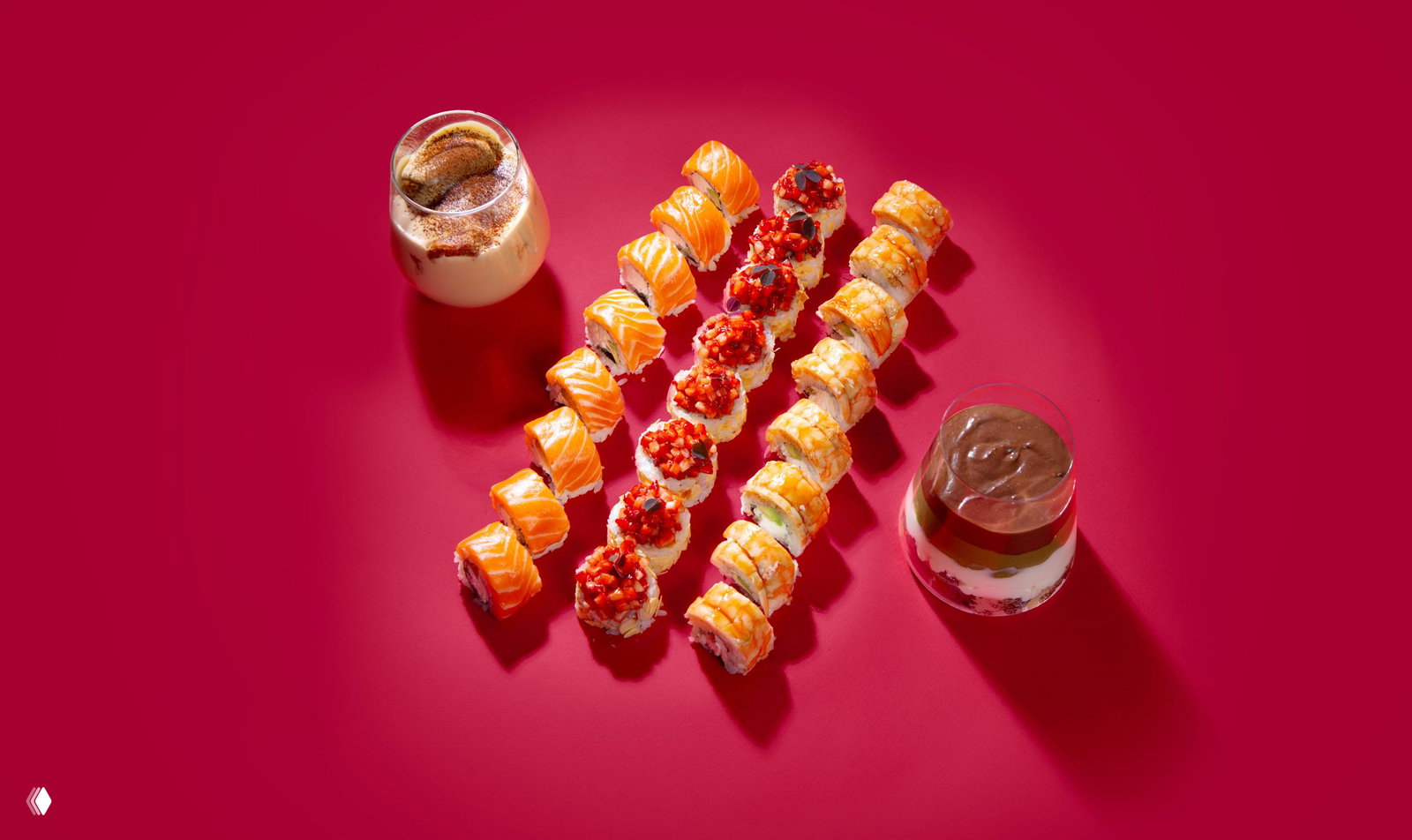Три ряда роллов и два десерта на бордовом фоне: наборы с Филадельфией, спешл-роллами с креветкой и клубникой из промо‑сета Yami Yami.