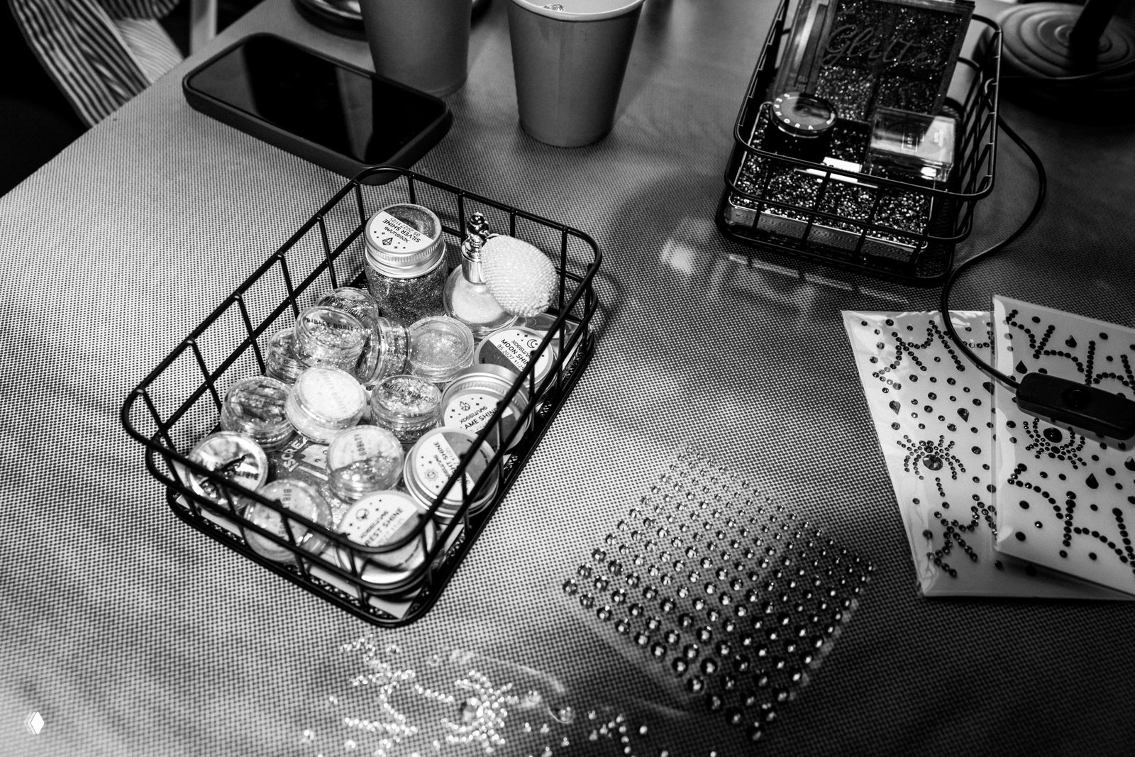 Стол с баночками блёсток, стразы и декоративными материалами — подготовка бьюти‑зоны и зоны с блестками для мероприятия.