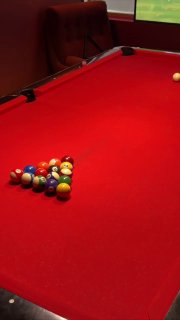 Бильярдный стол с расставленными шарами на красном сукне, подготовка к партии и акцент на развлечениях в флагманском OSSU