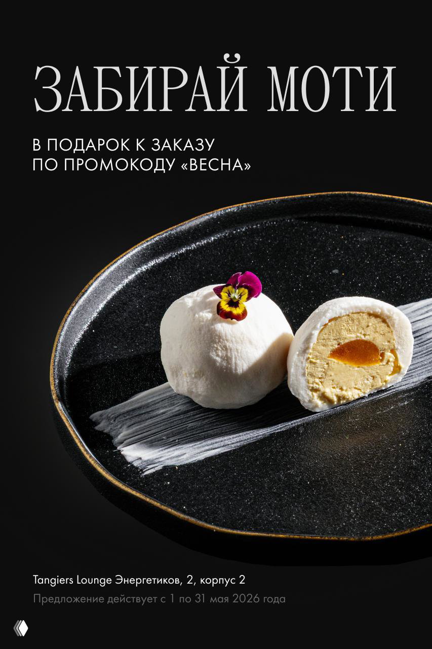 Черная тарелка с двумя белыми моти: один целый, второй разрезан, видно кремовую начинку и желтую прослойку — рекламный кадр промоакции.