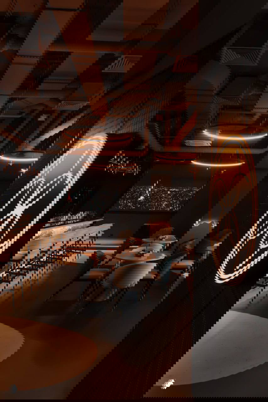 Тёмный гастрономический лаунж с барной стойкой и круглыми подвесными светильниками, атмосферный интерьер в концепции четырёх стихий.