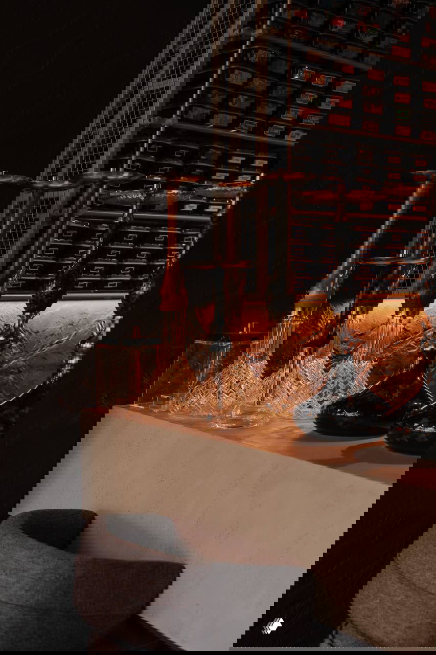 Крупный план стеклянных колб и металлических держателей на барной полке — элементы подачи и оформления бара в заведении.