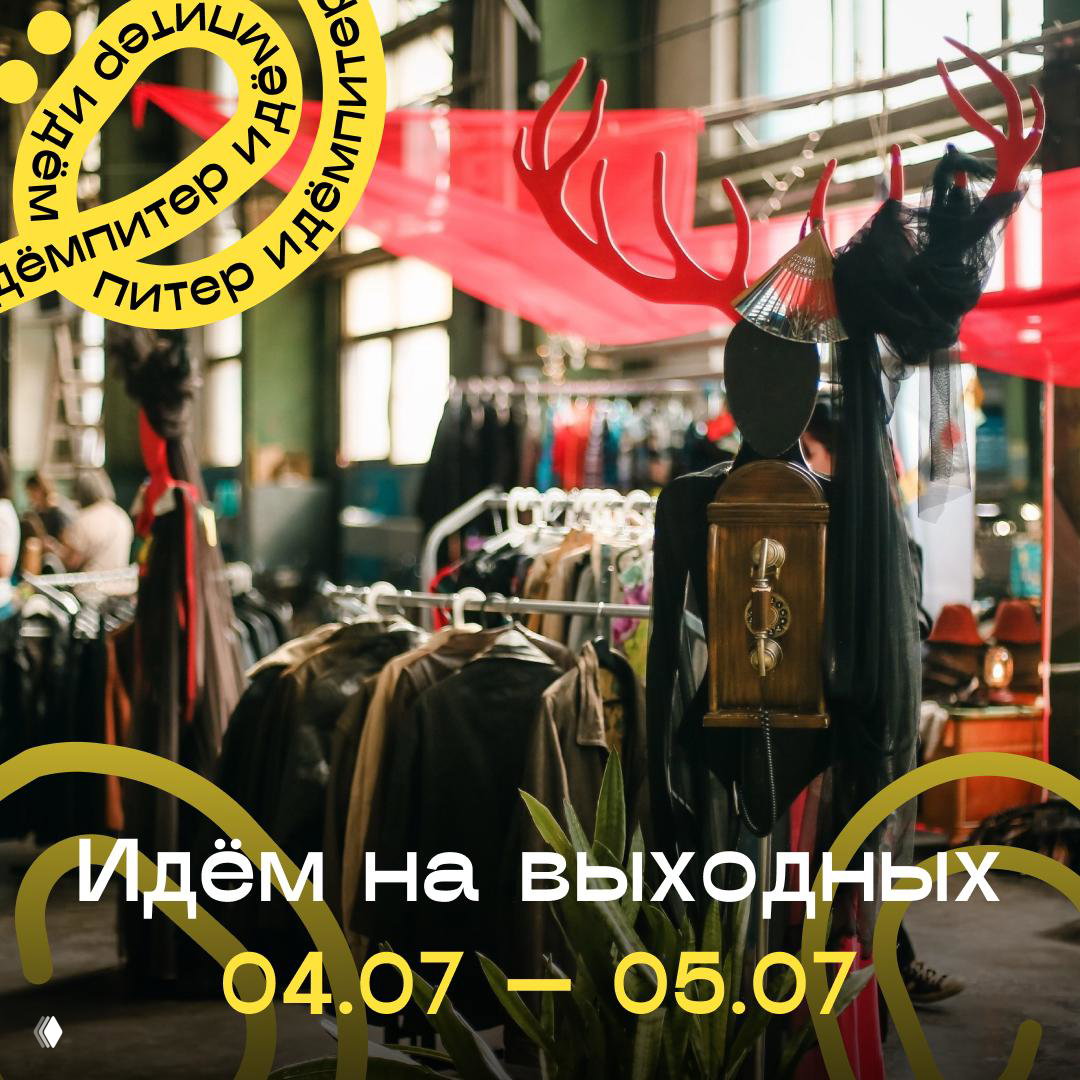 Маркет винтажной одежды и аксессуаров в зале: ряды вешалок с одеждой, манекен с декоративными рогами и праздничные баннеры на фоне.