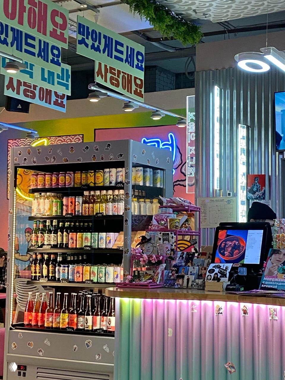 Интерьер и прилавок кафе «Чико» в корейском стиле: витрина с напитками, неон и касса, место проведения дегустации в Петербурге.