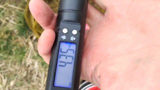 Рука держит электронные весы с показанием примерно 4.35 кг на фоне травы и земли — замер веса пойманного карпа.