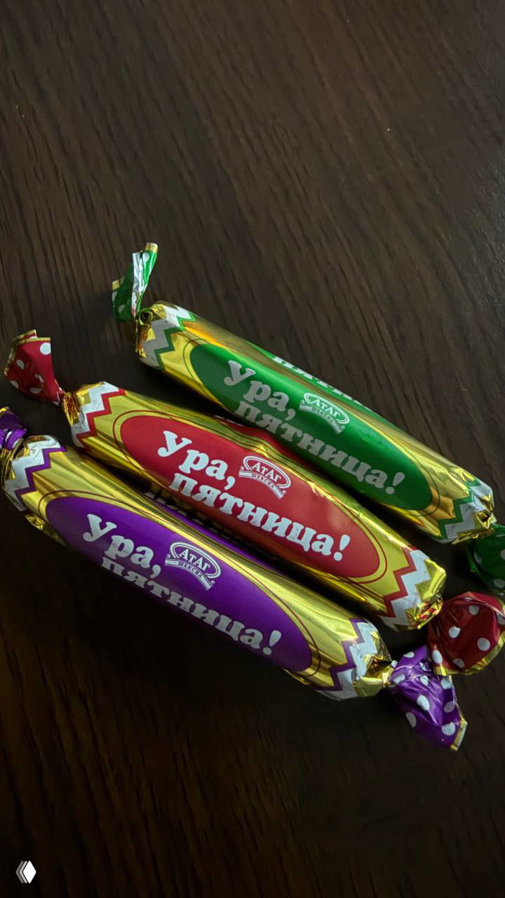 Три завернутые конфеты на тёмном фоне с надписью «Ура, пятница!» — угощение, которое приносили на встречу для создания домашнего настроя.