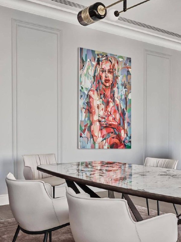 Обеденная зона с мраморным столом и кожаными креслами, на стене крупная цветная картина — яркий акцент в нейтральном интерьере.