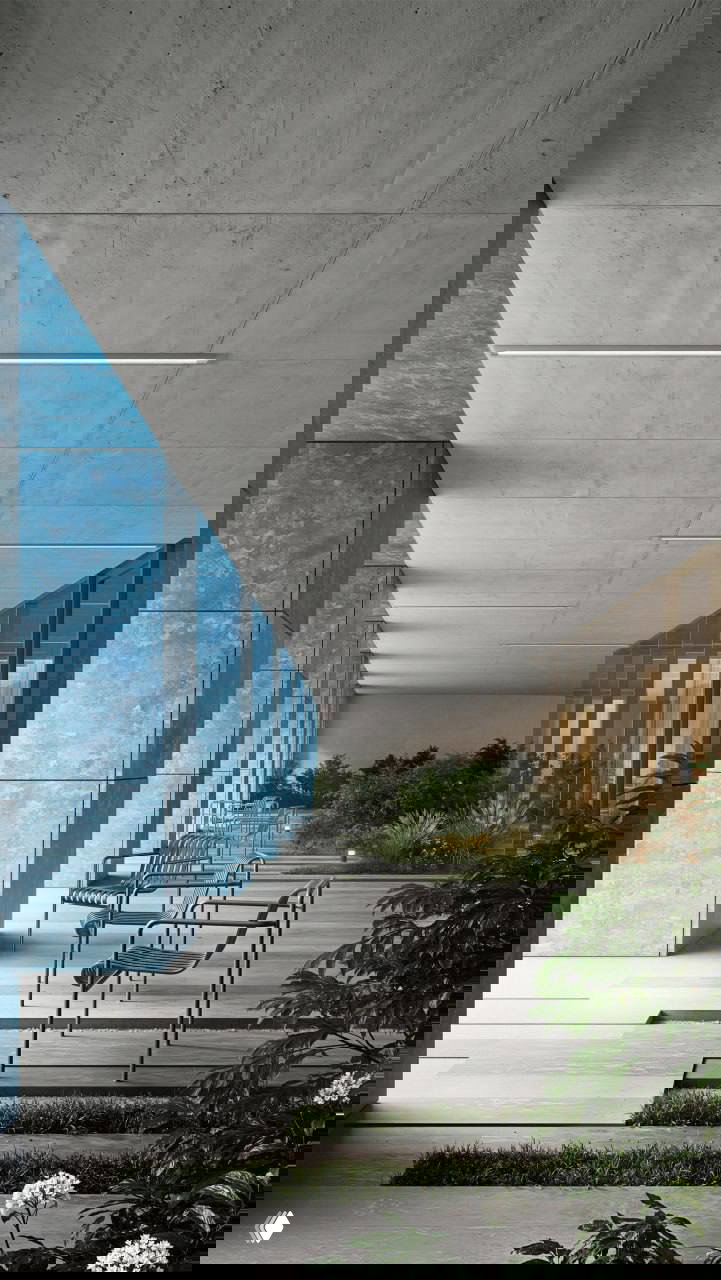 Внутренний проход между колоннами: ряд стульев, декоративная растительность и длинная перспектива коридора с синими облицовочными панелями и бетонным потолком.