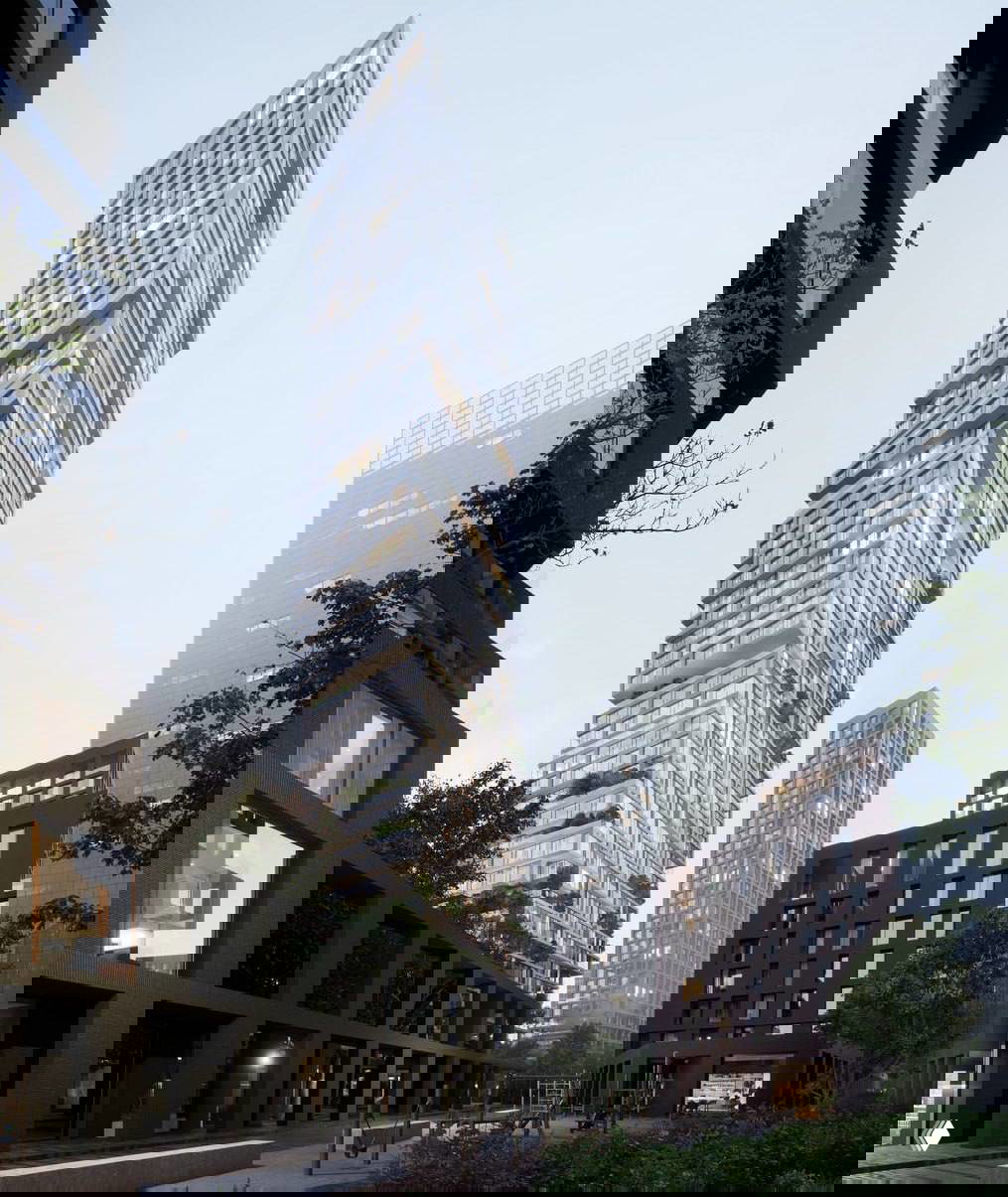 Общий вид ансамбля: ступенчатая башня среди соседних корпусов, благоустроенный двор с игровой зоной и вечерним освещением в окнах.