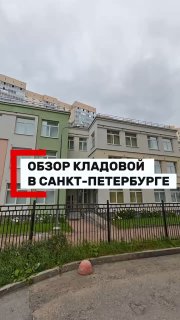 Фасад современного жилого комплекса в Парнасе с ограждением и входом в встроенное помещение кладовых; пасмурная погода над объектом