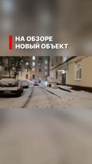 Снежный двор и входы в жилой дом: кадр из видеообзора нового объекта кладовых в подвале жилого дома с текстовым баннером сверху.