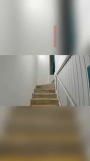 Внутренний вид лестницы и коридора в здании кладовых: белые стены, перила и дверцы секций, общий план интерьера объекта self‑storage.