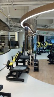 Рука держит смартфон с картой и меткой Shanghai на экране, на фоне городской улицы и зданий — ориентирование и навигация в городе.