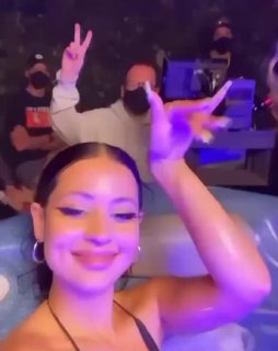 Короткий видеофрагмент с бэкстейджа: актриса улыбается в камеру под пурпурное освещение, на заднем плане съёмочная группа и техника.