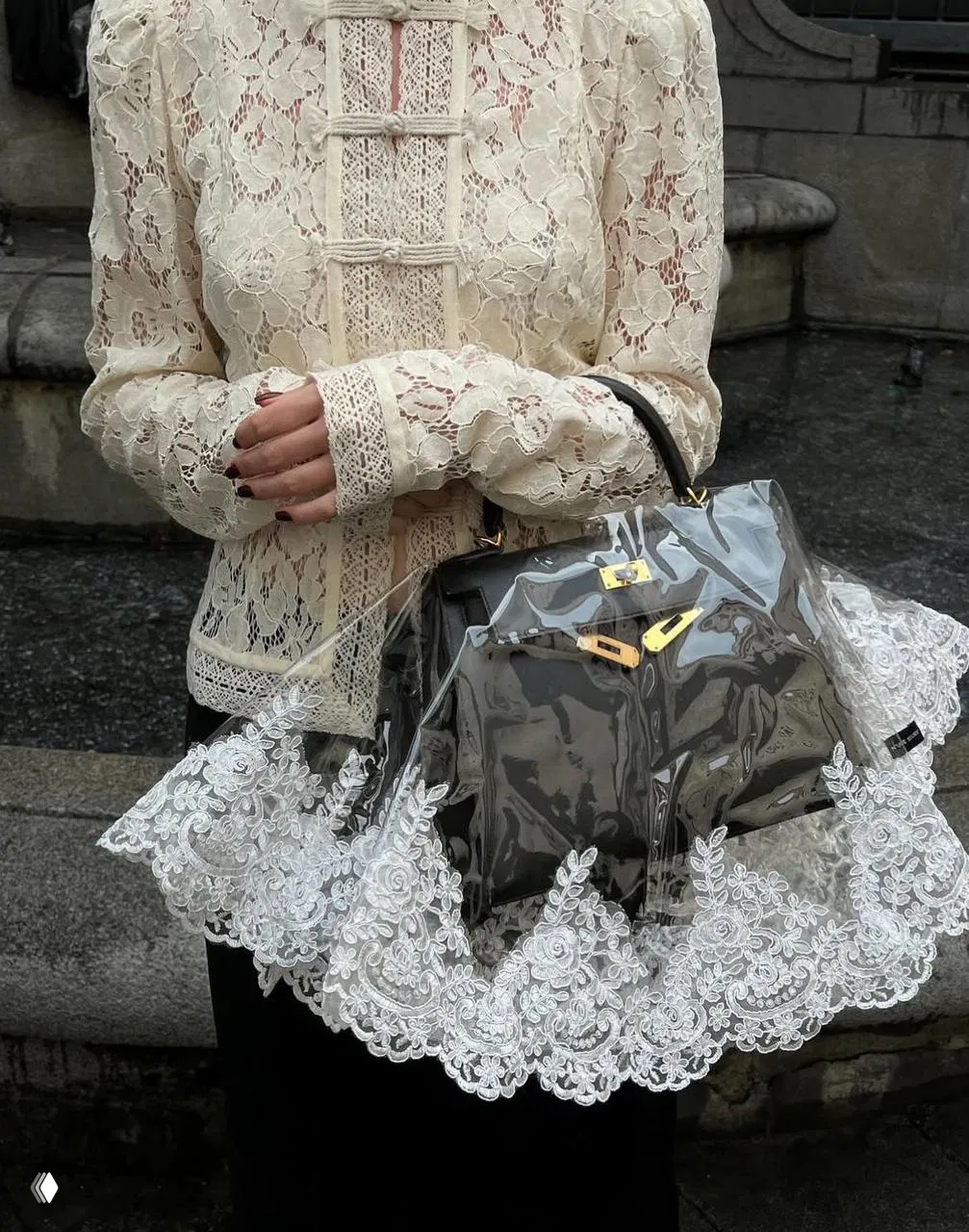 Кремовый кружевной жакет на девушке, прозрачная сумка с декоративным кружевом и чёрная сумка — уличный модный лук с кружевом.