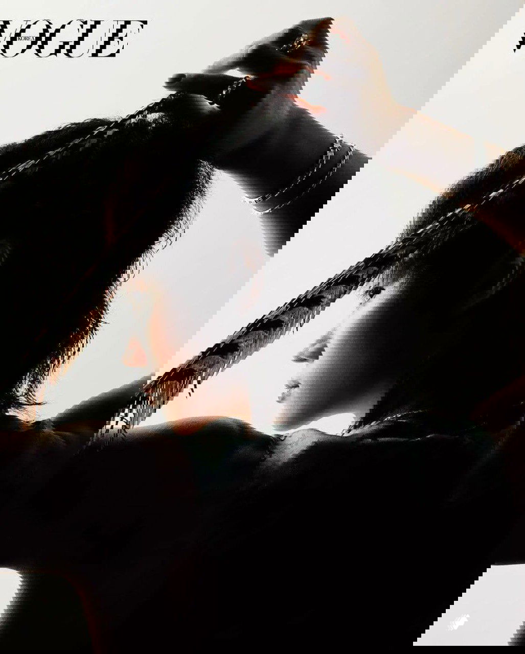 Силуэтный профиль модели в студийной подсветке: контрастный фон, перо в руке и лаконичная художественная постановка для обложки журнала.