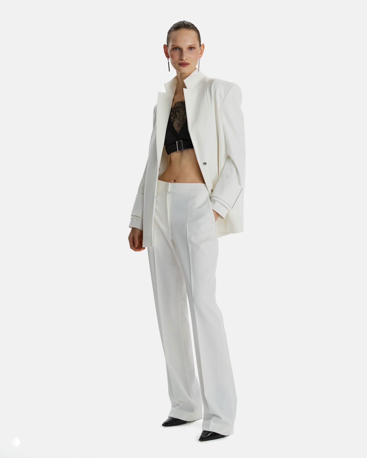 Модель в белом костюме и чёрном кружевном корсете — контраст белого и чёрного в образе LIZURA, строгие линии и женственность деталей.