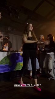 Вертикальный кадр диджей‑сета с танцующей фигурой и публикой; в кадре заметен яркий розовый акцент обуви и сценический свет.