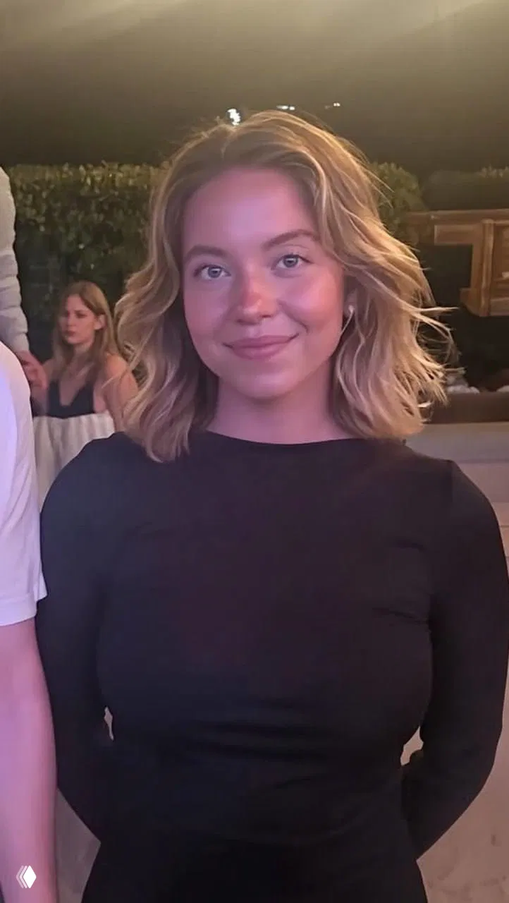 Фото женщины в тёплой обстановке на вечеринке: светлая укладка до плеч, естественная кожа без заметного макияжа и мягкое вечернее освещение.