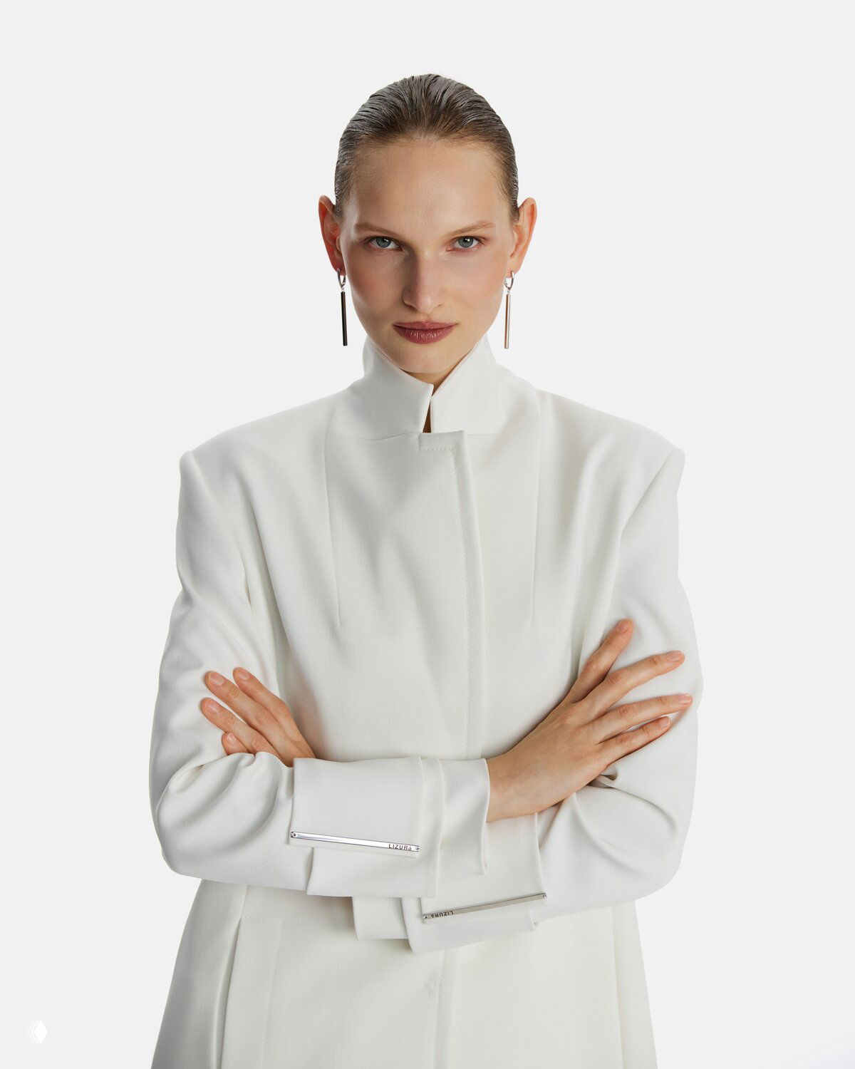 Крупный портрет модели в белом жакете, строгий взгляд и чистая эстетика фотосессии — визуальная концепция LIZURA: минимализм и сила линий.