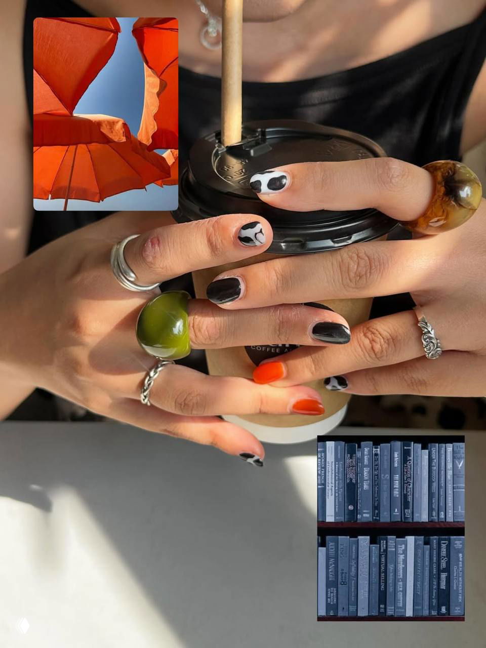 Руки с контрастным маникюром: чёрно‑белые узоры, яркие оранжевые акценты и мелкие декоративные детали, держат стакан с кофе в солнечном свете.