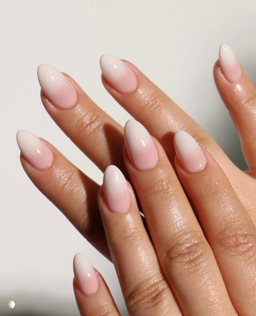 Овальные ногти с нежным розовым омбре и натуральной базой; мягкий градиент подчёркивает женственность и аккуратность маникюра.