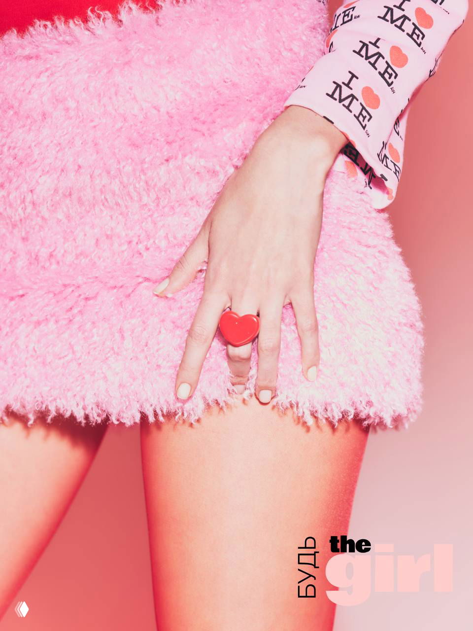 Крупный план рук и розовой пушистой юбки; сердечное кольцо и текстура ткани подчёркивают эстетику кампании «Будь theGirl».