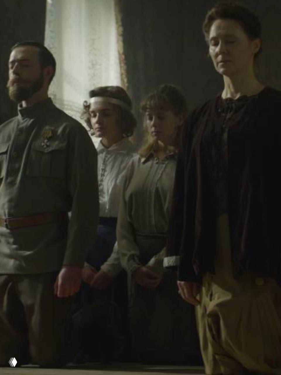 Тёмная сцена документального фильма о Романовых: фигуры людей на коленях в помещении, драматическое изображение заключения царской семьи.