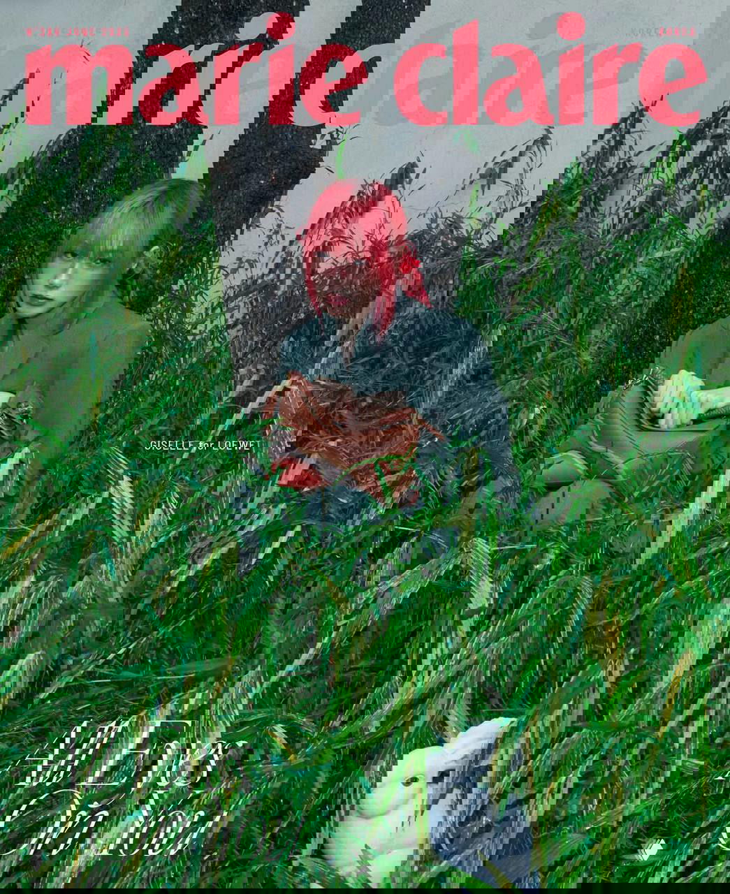 Яркая обложка журнала с артисткой в насыщенном красном образе среди зелёных растений, стилизованная фотосессия в природной сценографии.