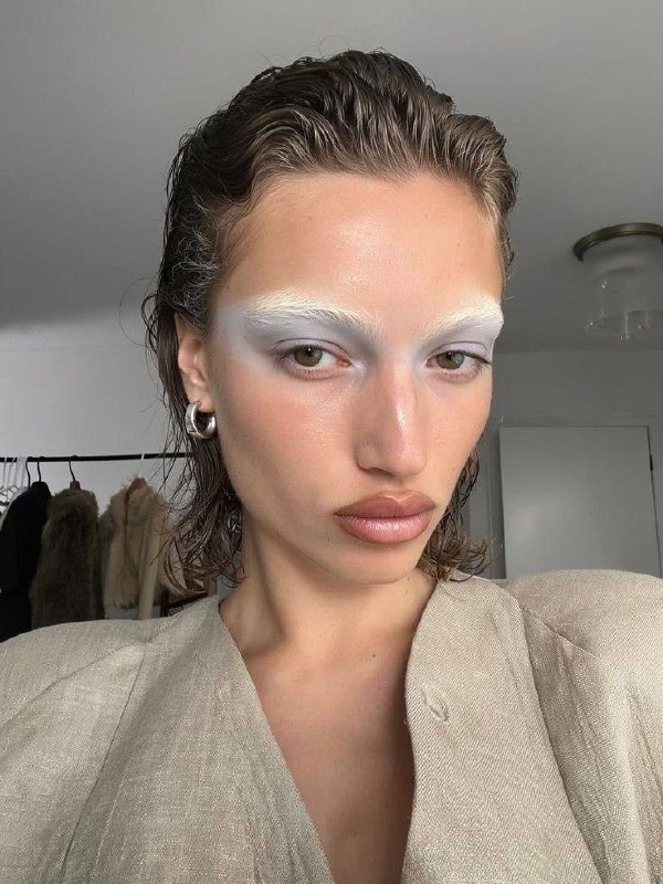 Близкий кадр модели с влажной причёской и бледными бровями, холодные голубовато‑серые тени создают минималистичный 90‑е образ.