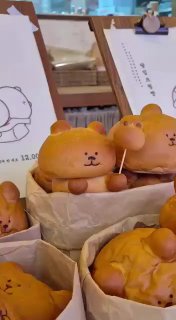 Фигурная выпечка в форме медвежат на стойке пекарни: милые «медвежьи» булочки рядом со стаканчиками кофе и декором кафе.