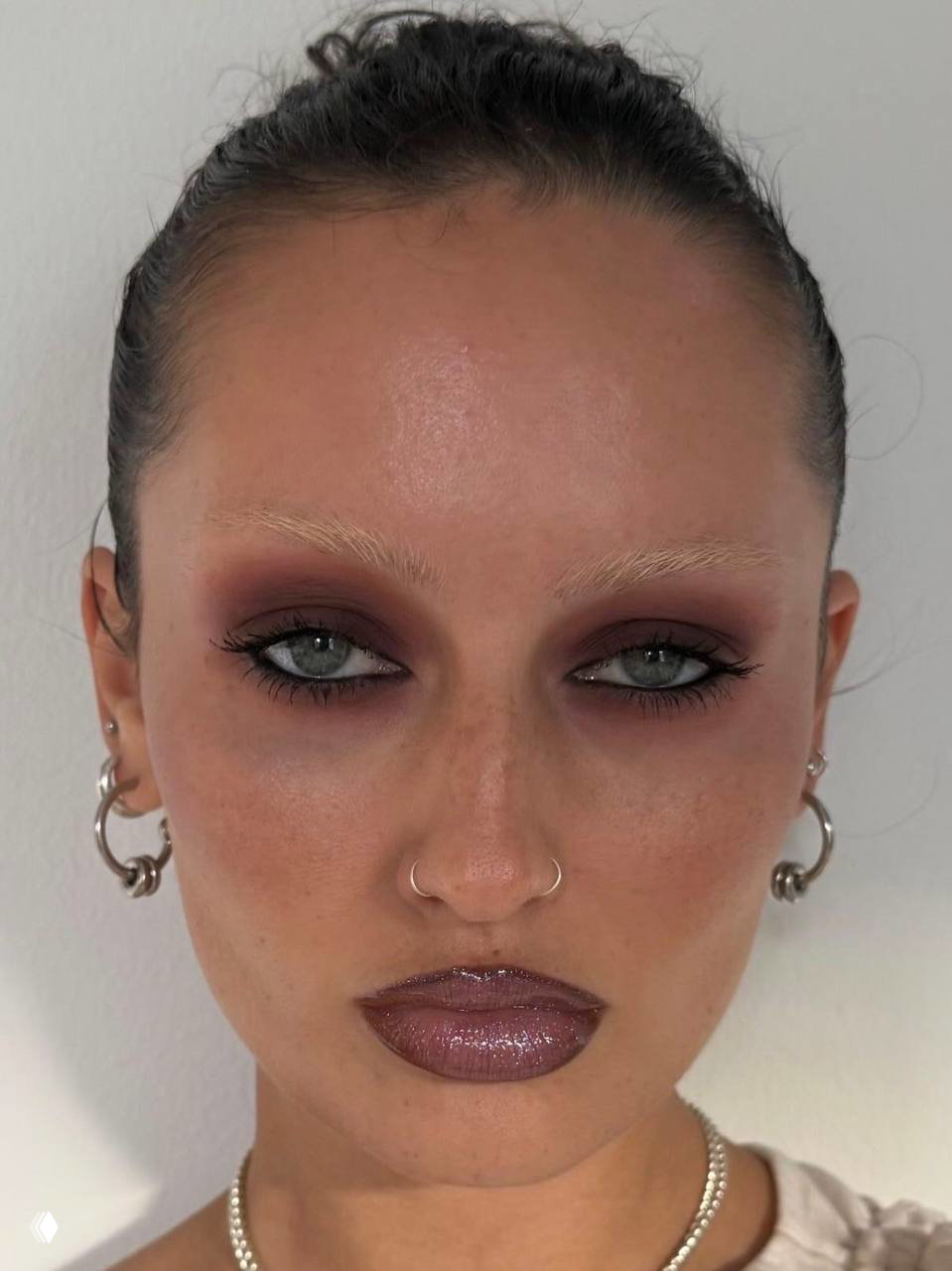 Портрет с глубоким коричневым дымчатым макияжем вокруг глаз, подчёркнутые скулы и глянцевые губы — современная интерпретация 90-х.