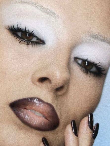 Крупный план с белыми тенями по подбровной зоне и чёрной подводкой, глянцевые тёмные губы и аккуратные ресницы в стиле ретро 90-х.