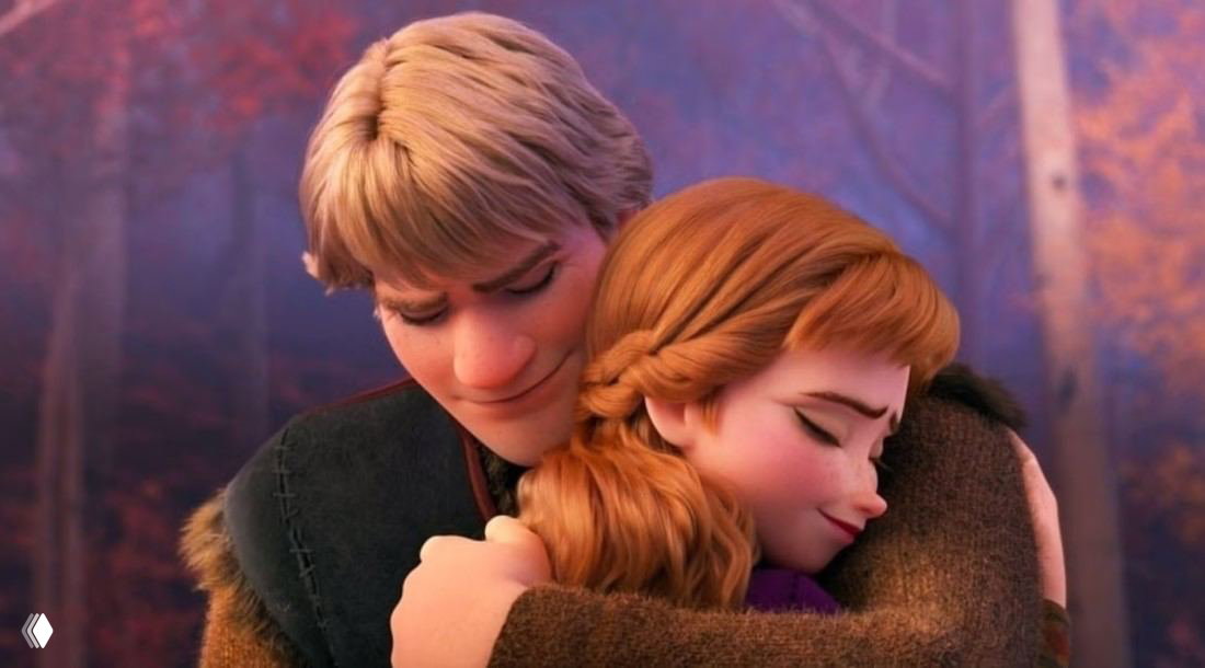 Кадр из «Холодного сердца»: Анна и Кристофф обнимаются в лесу, тёплый осенний свет и эмоциональная сцена из анимации.
